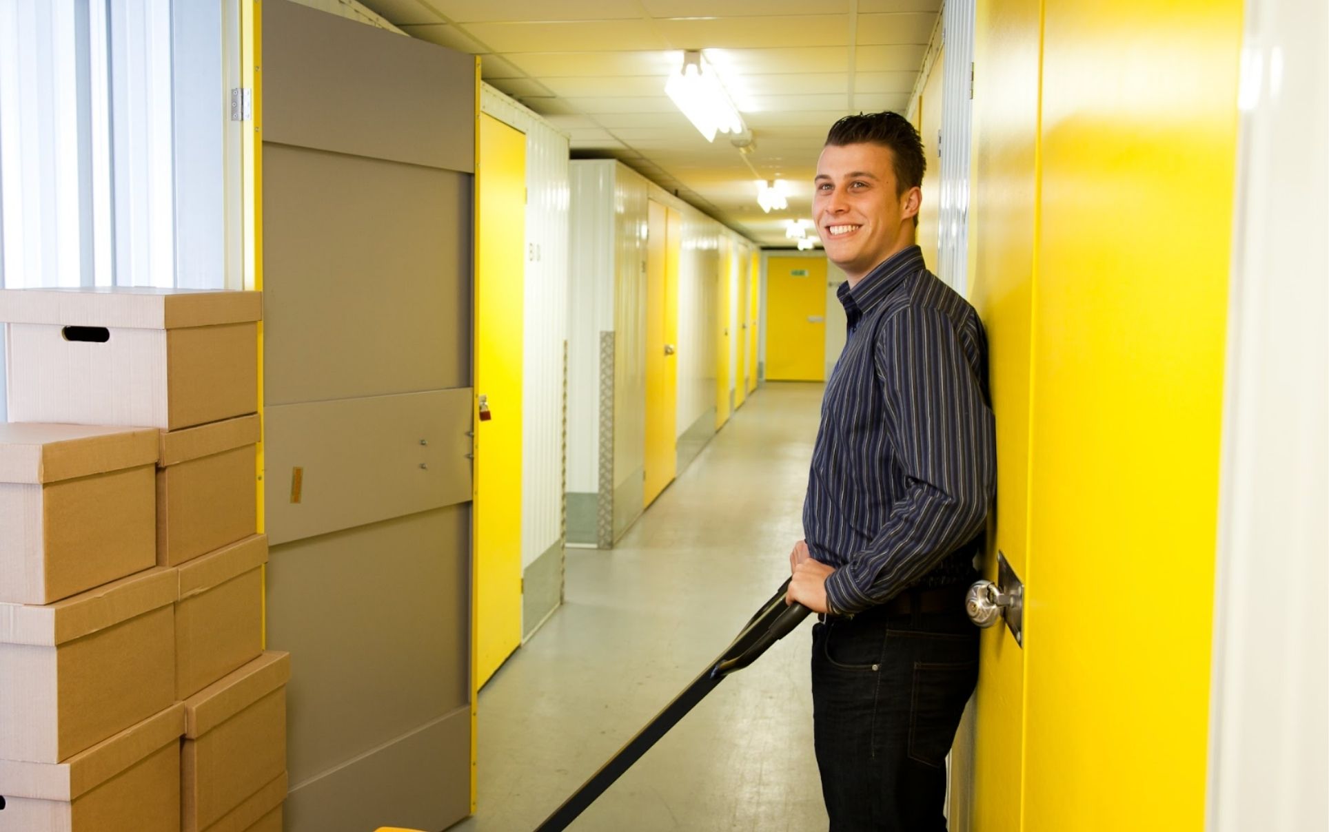 Man in storage unit facility loading yellow units